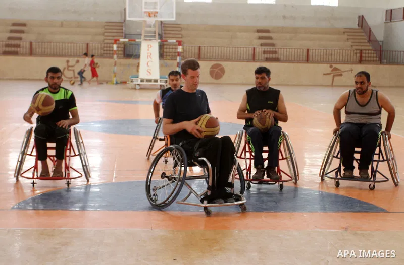 An American coach Jess marc, trains disabled Palestinians to play a basketball in Khan Younis in the southern Gaza strip, on May 26, 2016. Photo by Abed Rahim Khatib
