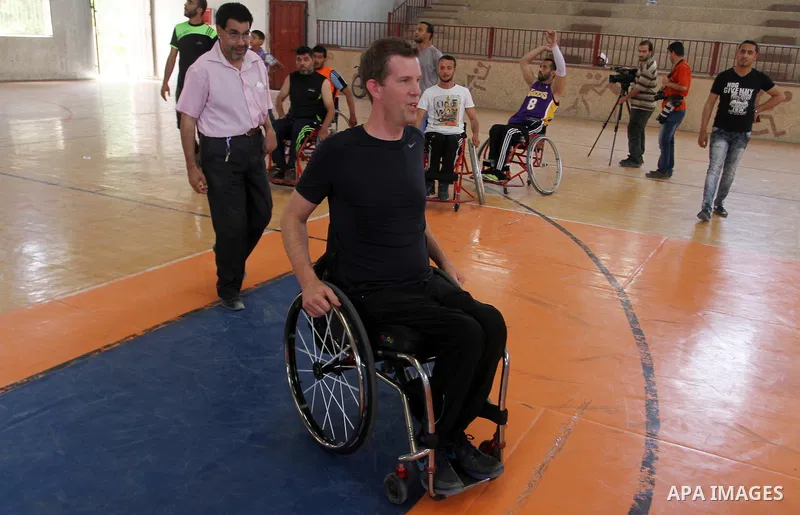 An American coach Jess marc, trains disabled Palestinians to play a basketball in Khan Younis in the southern Gaza strip, on May 26, 2016. Photo by Abed Rahim Khatib