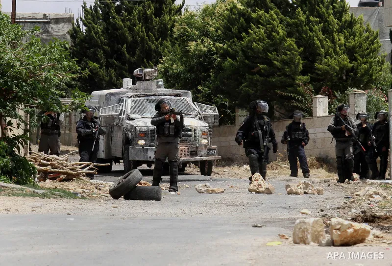 Israeli security forces aim at Palestinian protesters during clashes following a demonstration against the expropriation of Palestinian land by Israel, on May 27, 2016 in the village of Kfar Qaddum, near Nablus, in the o...
