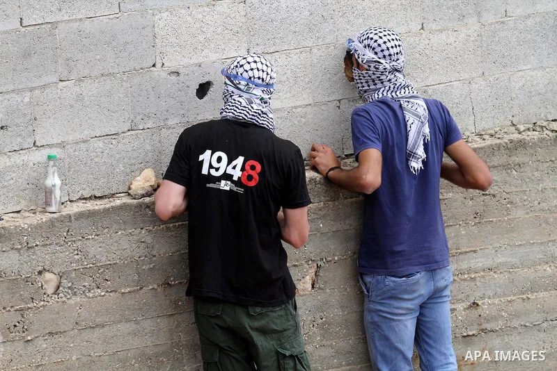 Palestinian protesters look on during clashes with Israeli security forces following a demonstration against the expropriation of Palestinian land by Israel, on May 27, 2016 in the village of Kfar Qaddum, near Nablus, in...