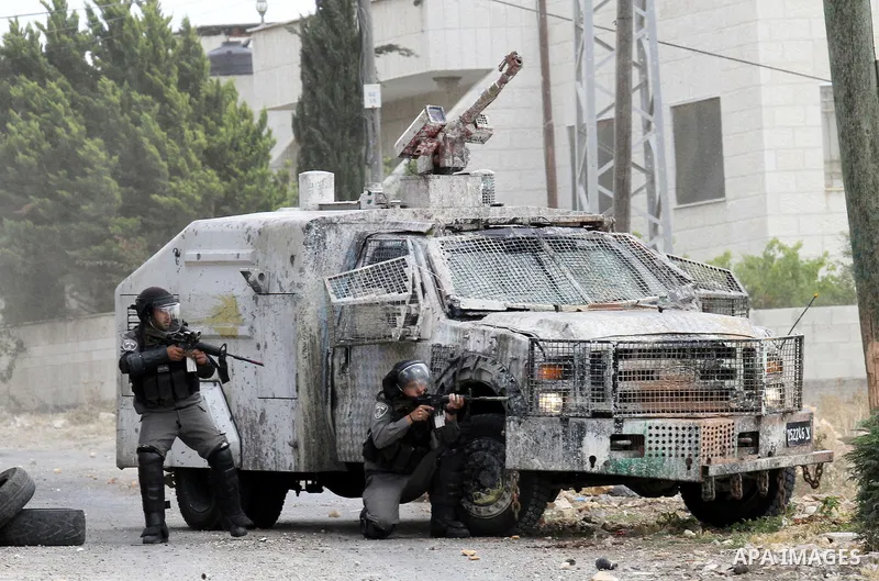 Israeli security forces aim at Palestinian protesters during clashes following a demonstration against the expropriation of Palestinian land by Israel, on May 27, 2016 in the village of Kfar Qaddum, near Nablus, in the o...