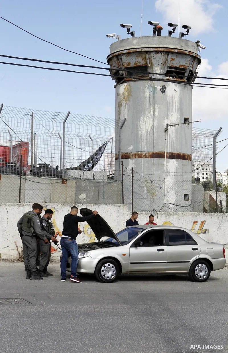 Israeli security forces inspect Palestinian cars in the West Bank village of Halhul, near Hebron, on May 27, 2016. Photo by Wisam Hashlamoun