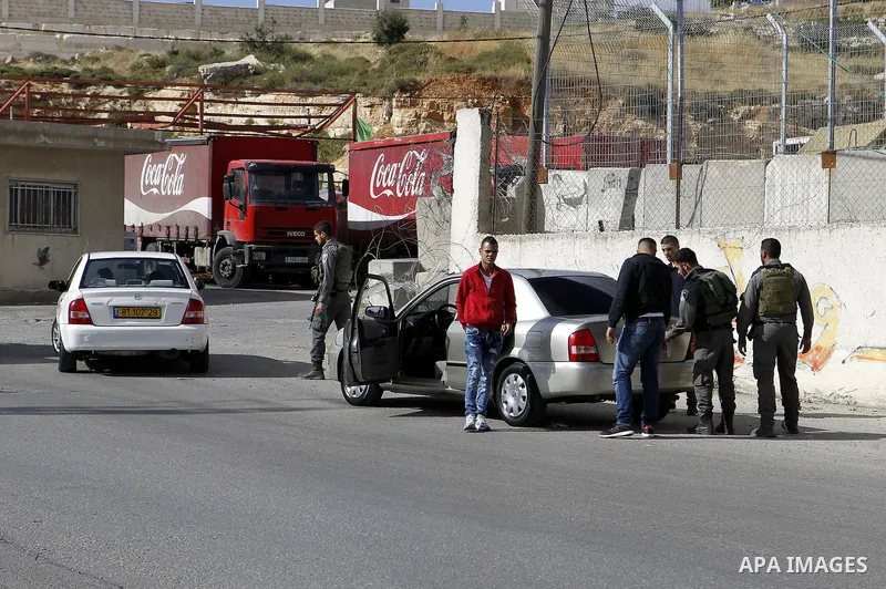 Israeli security forces inspect Palestinian cars in the West Bank village of Halhul, near Hebron, on May 27, 2016. Photo by Wisam Hashlamoun