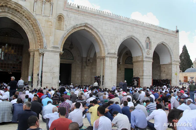 Palestinian Muslim worshipers attend Friday prayers outside al-Aqsa mosque, Islam's third holiest site, in Jerusalem's Old city on May, 27, 2016. Photo by Mahfouz Abu Turk