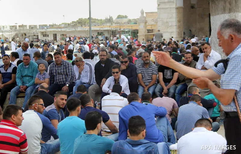 Palestinian Muslim worshipers attend Friday prayers outside al-Aqsa mosque, Islam's third holiest site, in Jerusalem's Old city on May, 27, 2016. Photo by Mahfouz Abu Turk