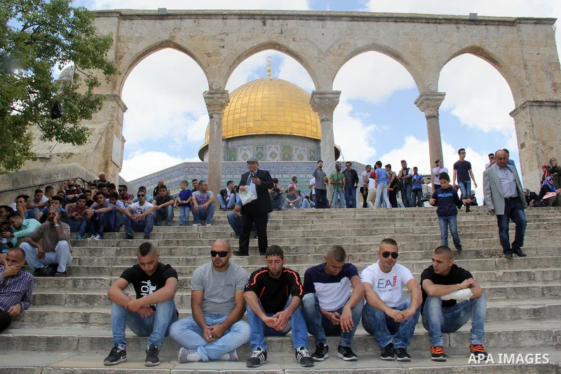 Palestinian Muslim worshipers attend Friday prayers outside al-Aqsa mosque, Islam's third holiest site, in Jerusalem's Old city on May, 27, 2016. Photo by Mahfouz Abu Turk