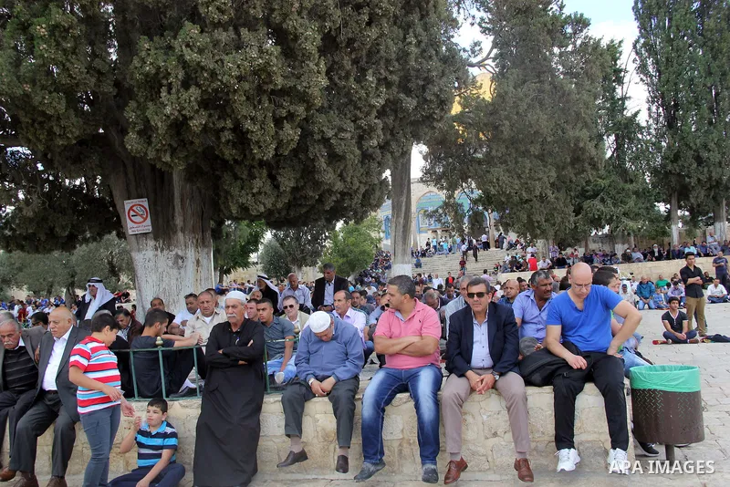 Palestinian Muslim worshipers attend Friday prayers outside al-Aqsa mosque, Islam's third holiest site, in Jerusalem's Old city on May, 27, 2016. Photo by Mahfouz Abu Turk