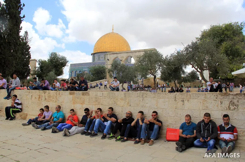 Palestinian Muslim worshipers attend Friday prayers outside al-Aqsa mosque, Islam's third holiest site, in Jerusalem's Old city on May, 27, 2016. Photo by Mahfouz Abu Turk