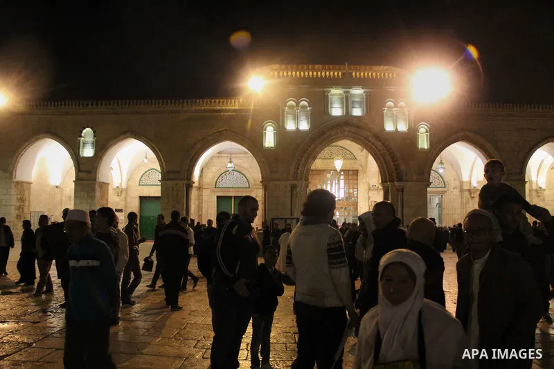 Palestinian Muslim worshipers walk in front of the Dome of the Rock mosque following Friday prayers at al-Aqsa mosque,Islam's third holiest site, in Jerusalem's Old city on May 27, 2016. Photo by Mahfouz Abu Turk