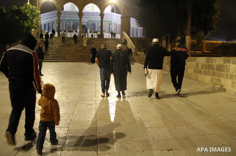 Palestinian Muslim worshipers walk in front of the Dome of the Rock mosque following Friday prayers at al-Aqsa mosque,Islam's third holiest site, in Jerusalem's Old city on May 27, 2016. Photo by Mahfouz Abu Turk