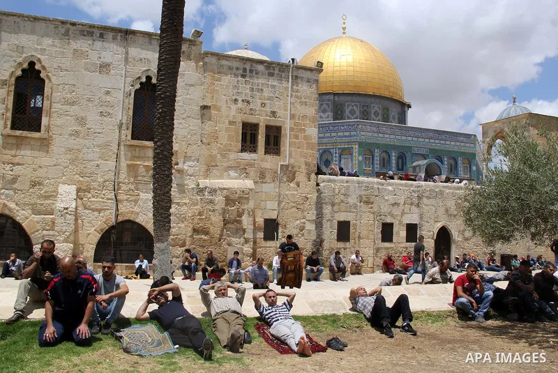 Palestinian Muslim worshipers attend Friday prayers outside al-Aqsa mosque, Islam's third holiest site, in Jerusalem's Old city on May, 27, 2016. Photo by Mahfouz Abu Turk