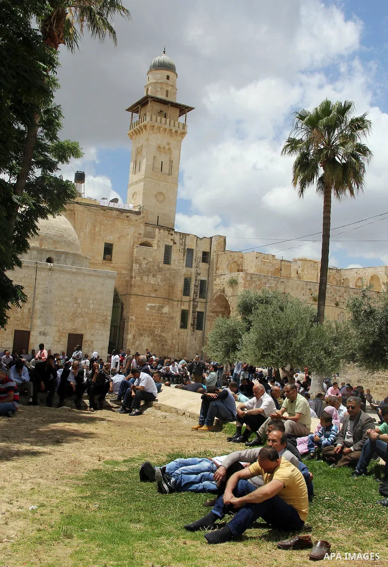Palestinian Muslim worshipers attend Friday prayers outside al-Aqsa mosque, Islam's third holiest site, in Jerusalem's Old city on May, 27, 2016. Photo by Mahfouz Abu Turk
