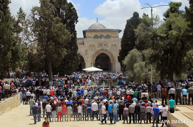 Palestinian Muslim worshipers attend Friday prayers outside al-Aqsa mosque, Islam's third holiest site, in Jerusalem's Old city on May, 27, 2016. Photo by Mahfouz Abu Turk