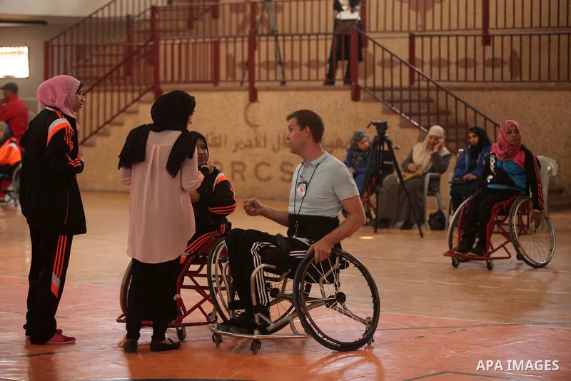 An American coach Jess marc, trains disabled Palestinians to play a basketball during a training course organised by the Palestinian Red Cross, in Khan Younis in the southern Gaza strip, on May 28, 2016. Photo by Ashraf...