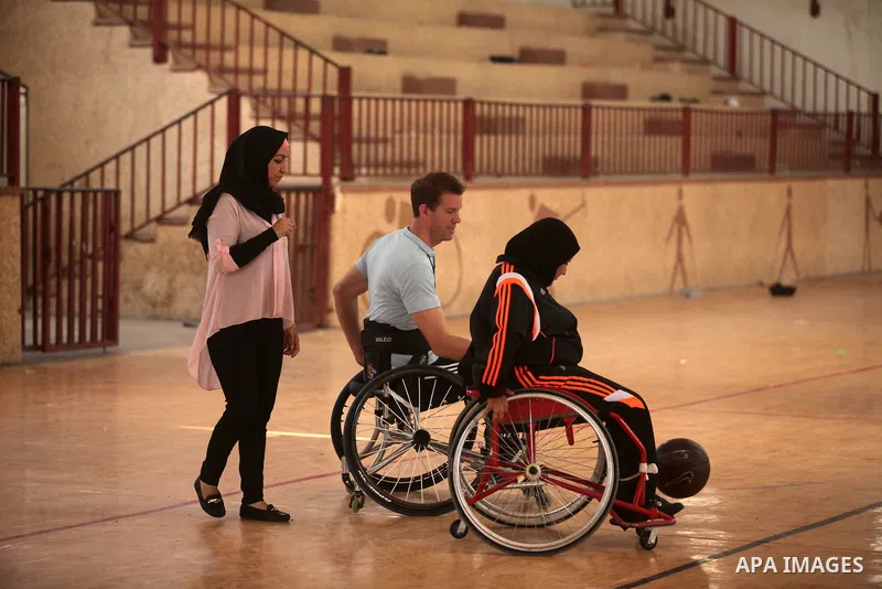 An American coach Jess marc, trains disabled Palestinians to play a basketball during a training course organised by the Palestinian Red Cross, in Khan Younis in the southern Gaza strip, on May 28, 2016. Photo by Ashraf...