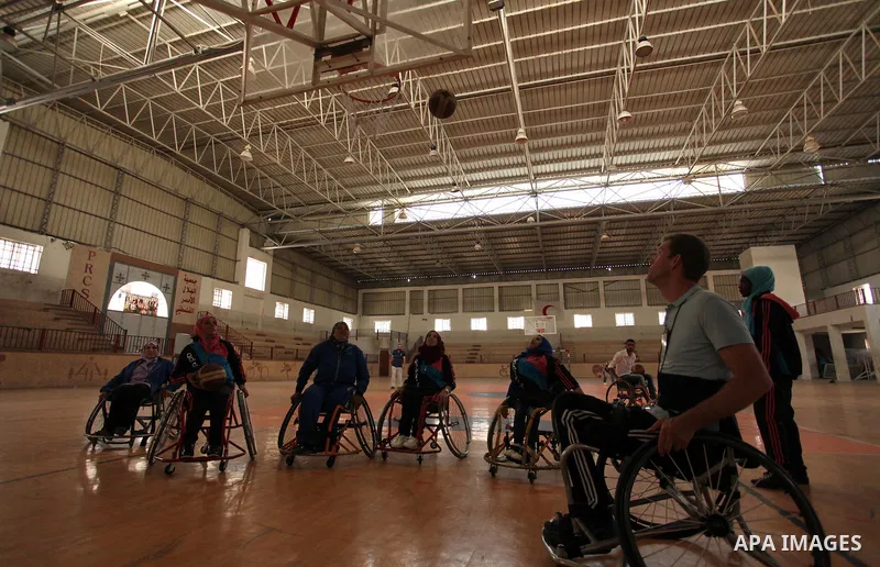 An American coach Jess marc, trains disabled Palestinians to play a basketball during a training course organised by the Palestinian Red Cross, in Khan Younis in the southern Gaza strip, on May 28, 2016. Photo by Ashraf...