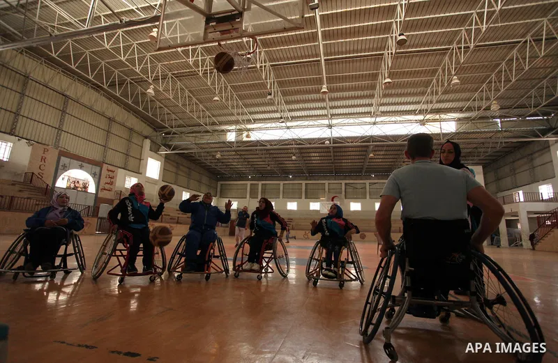 An American coach Jess marc, trains disabled Palestinians to play a basketball during a training course organised by the Palestinian Red Cross, in Khan Younis in the southern Gaza strip, on May 28, 2016. Photo by Ashraf...