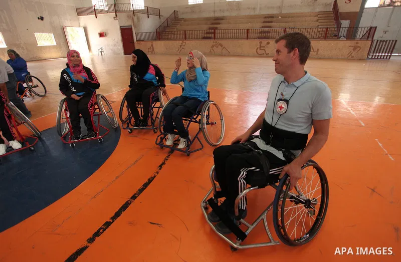 An American coach Jess marc, trains disabled Palestinians to play a basketball during a training course organised by the Palestinian Red Cross, in Khan Younis in the southern Gaza strip, on May 28, 2016. Photo by Ashraf...