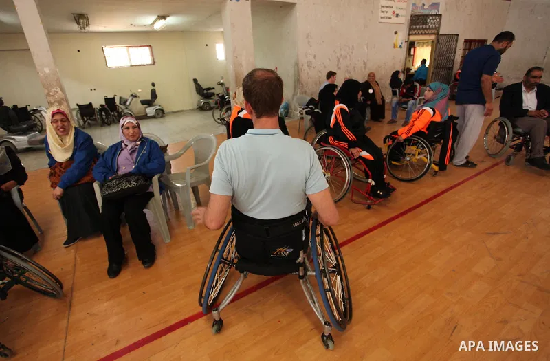 An American coach Jess marc, trains disabled Palestinians to play a basketball during a training course organised by the Palestinian Red Cross, in Khan Younis in the southern Gaza strip, on May 28, 2016. Photo by Ashraf...