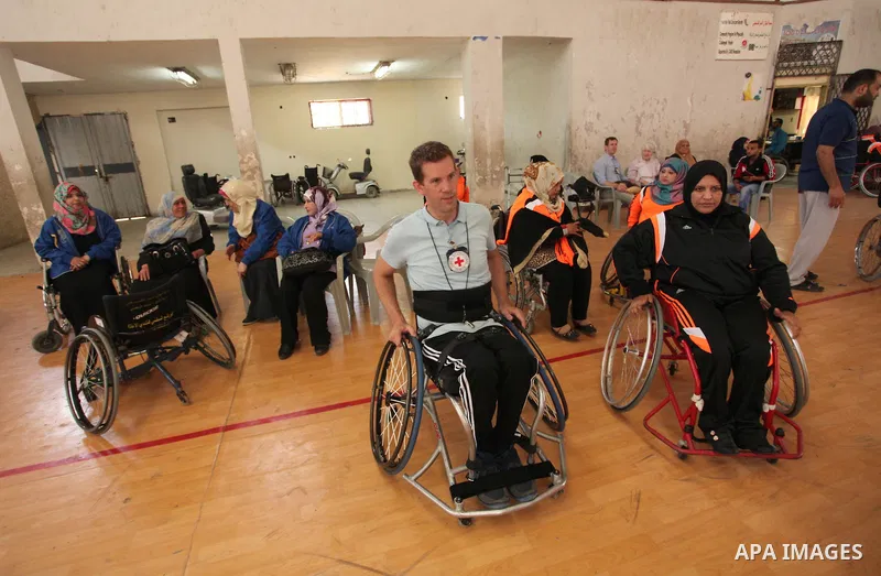 An American coach Jess marc, trains disabled Palestinians to play a basketball during a training course organised by the Palestinian Red Cross, in Khan Younis in the southern Gaza strip, on May 28, 2016. Photo by Ashraf...