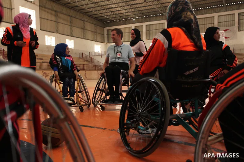 An American coach Jess marc, trains disabled Palestinians to play a basketball during a training course organised by the Palestinian Red Cross, in Khan Younis in the southern Gaza strip, on May 28, 2016. Photo by Ashraf...