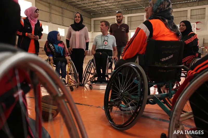 An American coach Jess marc, trains disabled Palestinians to play a basketball during a training course organised by the Palestinian Red Cross, in Khan Younis in the southern Gaza strip, on May 28, 2016. Photo by Ashraf...