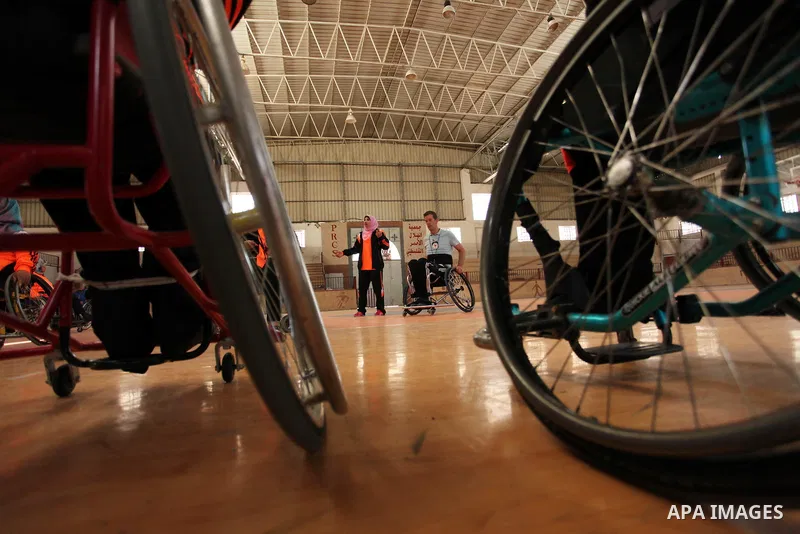 An American coach Jess marc, trains disabled Palestinians to play a basketball during a training course organised by the Palestinian Red Cross, in Khan Younis in the southern Gaza strip, on May 28, 2016. Photo by Ashraf...
