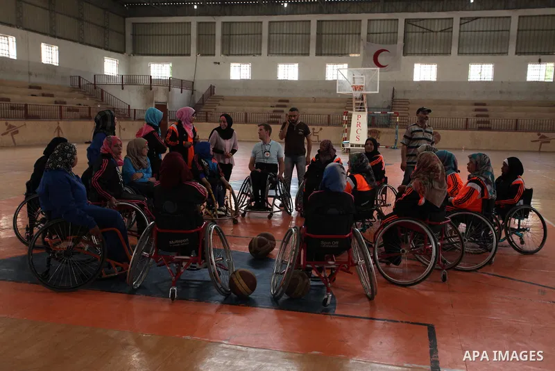 An American coach Jess marc, trains disabled Palestinians to play a basketball during a training course organised by the Palestinian Red Cross, in Khan Younis in the southern Gaza strip, on May 28, 2016. Photo by Ashraf...