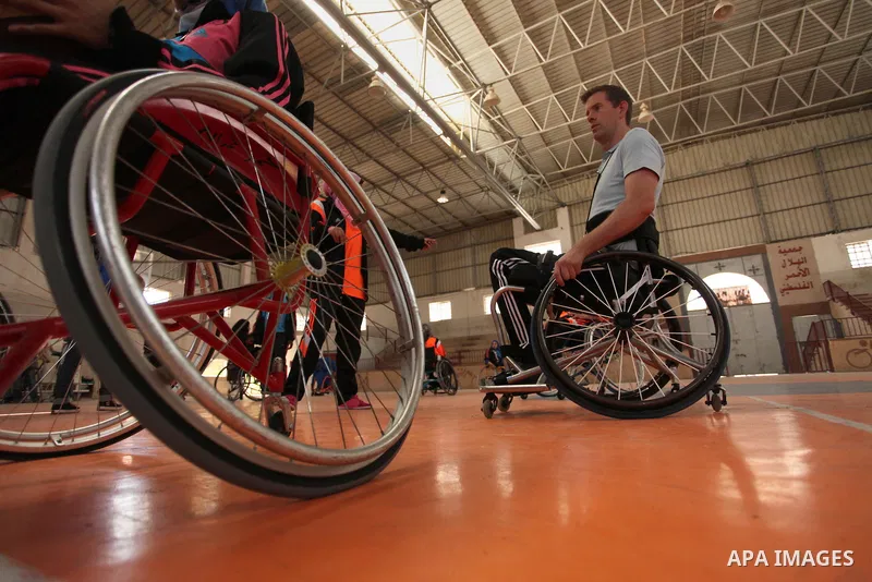 An American coach Jess marc, trains disabled Palestinians to play a basketball during a training course organised by the Palestinian Red Cross, in Khan Younis in the southern Gaza strip, on May 28, 2016. Photo by Ashraf...