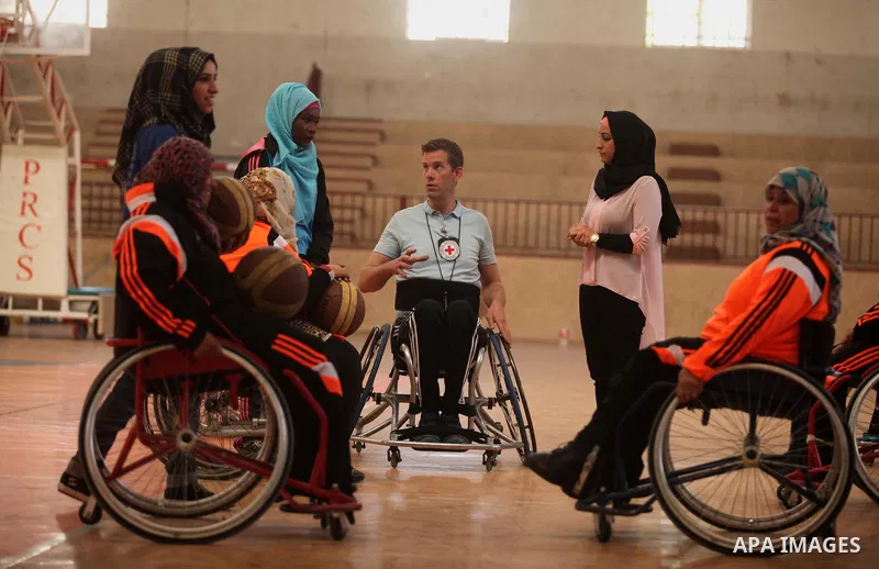 An American coach Jess marc, trains disabled Palestinians to play a basketball during a training course organised by the Palestinian Red Cross, in Khan Younis in the southern Gaza strip, on May 28, 2016. Photo by Ashraf...