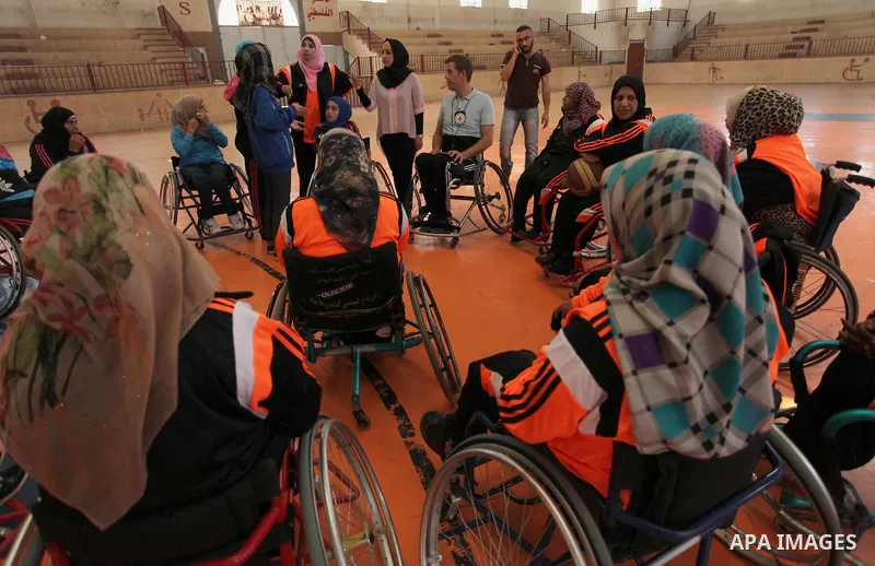 An American coach Jess marc, trains disabled Palestinians to play a basketball during a training course organised by the Palestinian Red Cross, in Khan Younis in the southern Gaza strip, on May 28, 2016. Photo by Ashraf...