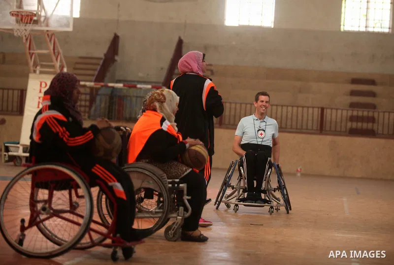 An American coach Jess marc, trains disabled Palestinians to play a basketball during a training course organised by the Palestinian Red Cross, in Khan Younis in the southern Gaza strip, on May 28, 2016. Photo by Ashraf...