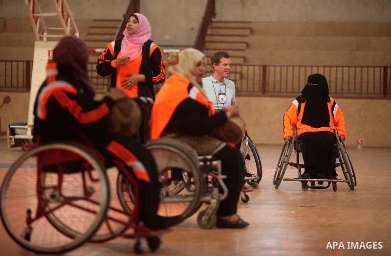 An American coach Jess marc, trains disabled Palestinians to play a basketball during a training course organised by the Palestinian Red Cross, in Khan Younis in the southern Gaza strip, on May 28, 2016. Photo by Ashraf...