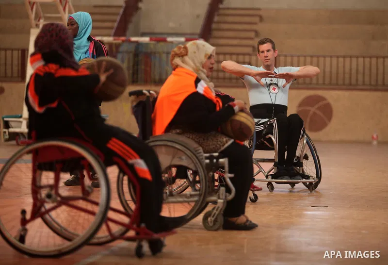 An American coach Jess marc, trains disabled Palestinians to play a basketball during a training course organised by the Palestinian Red Cross, in Khan Younis in the southern Gaza strip, on May 28, 2016. Photo by Ashraf...