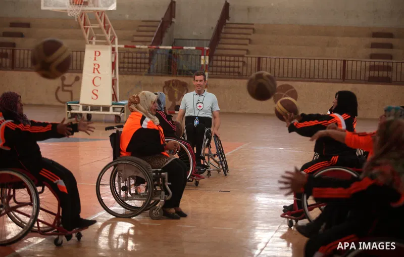 An American coach Jess marc, trains disabled Palestinians to play a basketball during a training course organised by the Palestinian Red Cross, in Khan Younis in the southern Gaza strip, on May 28, 2016. Photo by Ashraf...