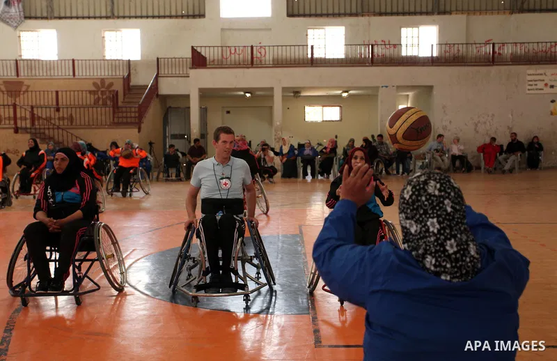 An American coach Jess marc, trains disabled Palestinians to play a basketball during a training course organised by the Palestinian Red Cross, in Khan Younis in the southern Gaza strip, on May 28, 2016. Photo by Ashraf...