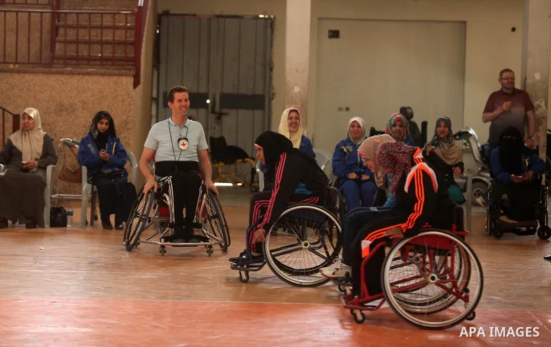 An American coach Jess marc, trains disabled Palestinians to play a basketball during a training course organised by the Palestinian Red Cross, in Khan Younis in the southern Gaza strip, on May 28, 2016. Photo by Ashraf...