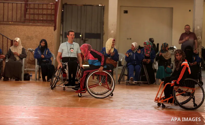 An American coach Jess marc, trains disabled Palestinians to play a basketball during a training course organised by the Palestinian Red Cross, in Khan Younis in the southern Gaza strip, on May 28, 2016. Photo by Ashraf...