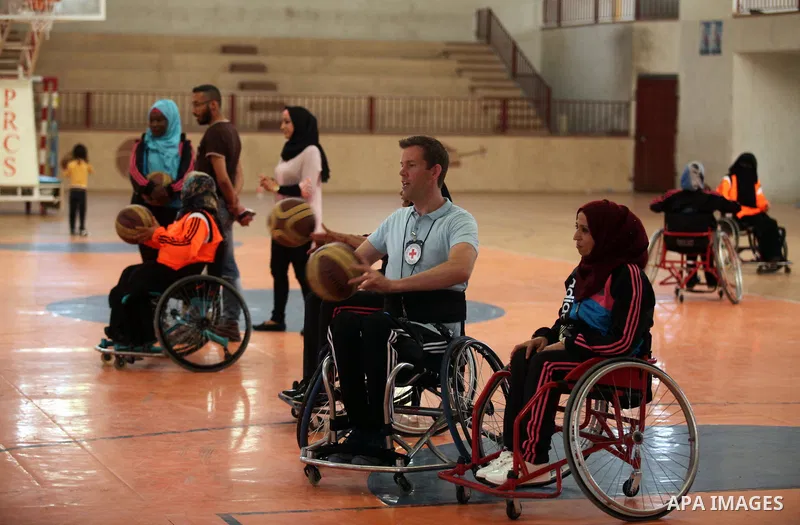 An American coach Jess marc, trains disabled Palestinians to play a basketball during a training course organised by the Palestinian Red Cross, in Khan Younis in the southern Gaza strip, on May 28, 2016. Photo by Ashraf...