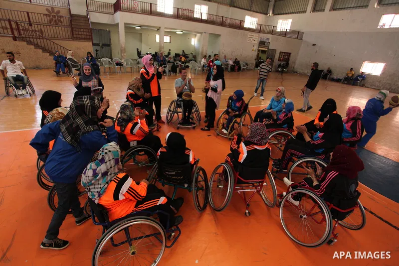 An American coach Jess marc, trains disabled Palestinians to play a basketball during a training course organised by the Palestinian Red Cross, in Khan Younis in the southern Gaza strip, on May 28, 2016. Photo by Ashraf...