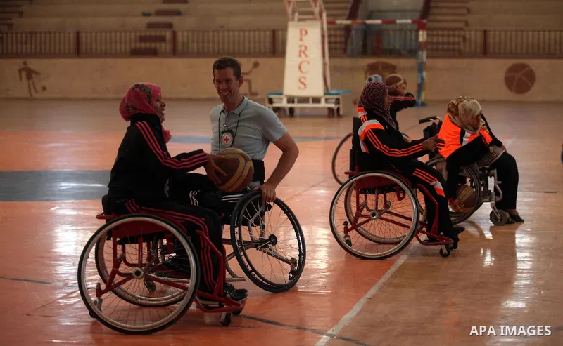 An American coach Jess marc, trains disabled Palestinians to play a basketball during a training course organised by the Palestinian Red Cross, in Khan Younis in the southern Gaza strip, on May 28, 2016. Photo by Ashraf...