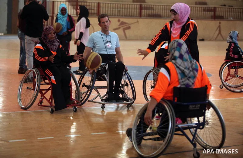 An American coach Jess marc, trains disabled Palestinians to play a basketball during a training course organised by the Palestinian Red Cross, in Khan Younis in the southern Gaza strip, on May 28, 2016. Photo by Ashraf...