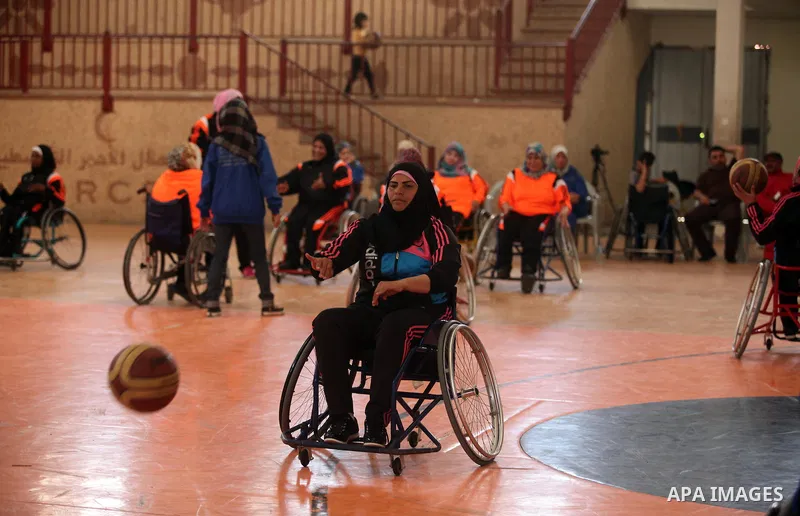 An American coach Jess marc, trains disabled Palestinians to play a basketball during a training course organised by the Palestinian Red Cross, in Khan Younis in the southern Gaza strip, on May 28, 2016. Photo by Ashraf...