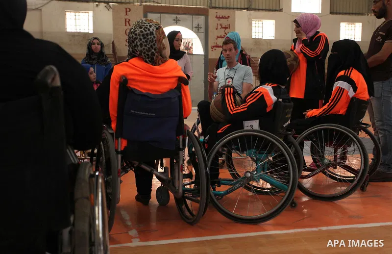 An American coach Jess marc, trains disabled Palestinians to play a basketball during a training course organised by the Palestinian Red Cross, in Khan Younis in the southern Gaza strip, on May 28, 2016. Photo by Ashraf...