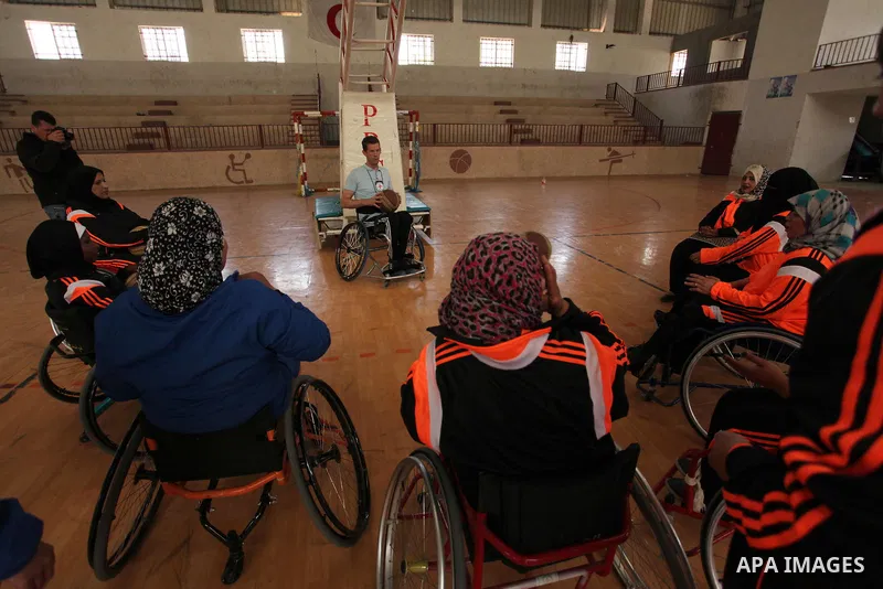 An American coach Jess marc, trains disabled Palestinians to play a basketball during a training course organised by the Palestinian Red Cross, in Khan Younis in the southern Gaza strip, on May 28, 2016. Photo by Ashraf...