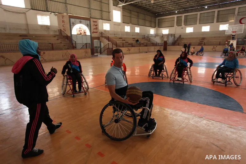 An American coach Jess marc, trains disabled Palestinians to play a basketball during a training course organised by the Palestinian Red Cross, in Khan Younis in the southern Gaza strip, on May 28, 2016. Photo by Ashraf...