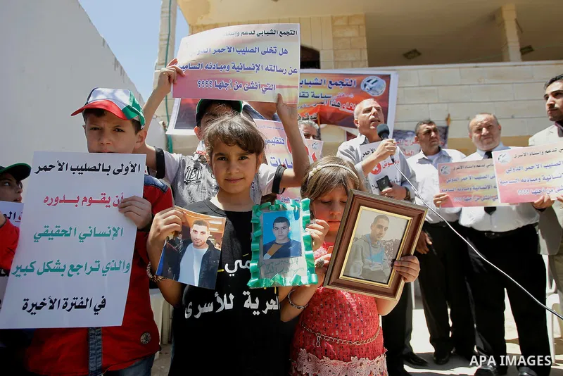 Palestinians take part in a protest to solidarity with the prisoners in Israeli jails, in front of Red cross office, in the West Bank city of Hebron, on May 30, 2016. Photo by Wisam Hashlamoun
