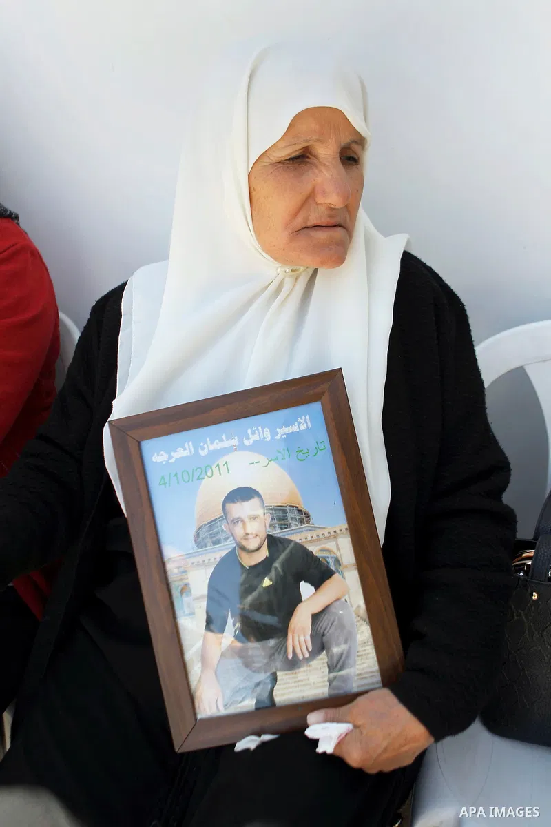 Palestinians take part in a protest to solidarity with the prisoners in Israeli jails, in front of Red cross office, in the West Bank city of Hebron, on May 30, 2016. Photo by Wisam Hashlamoun