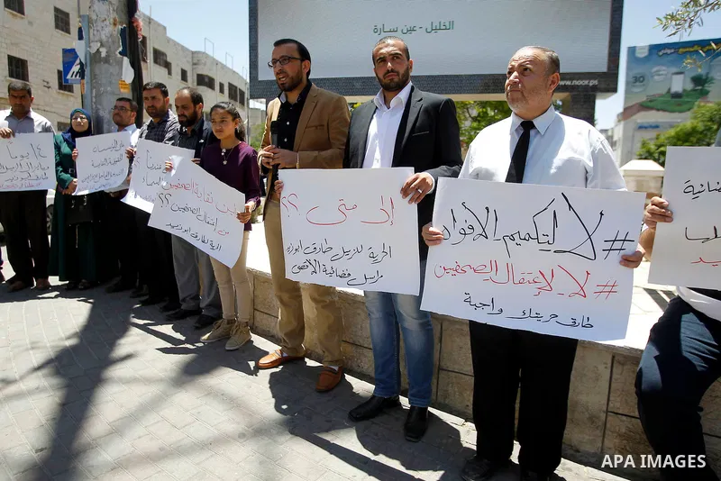 Palestinian journalists take part in a protest demanding the released for their colleague, Tareq Abu Zaid, the Journalist of Al-Aqsa TV, detained by Palestinian Authority, in the West bank city of Hebron, on May 30, 2016...