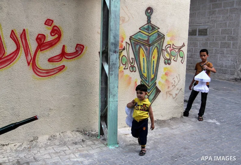 A Palestinian boy holds a traditional lanterns known in Arabic as "Fanous" that are used during the holy month of Ramadan in the Rafah refugee camp in southern Gaza Strip on May 30, 2016. Photo by Abed Rahim Khatib